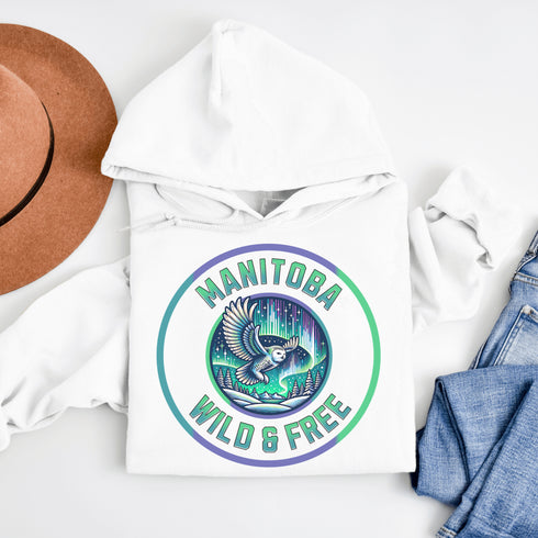 Embrace the magic of the prairies with our Manitoba – Wild & Free hoodie, featuring a captivating graphic of a snowy owl in flight beneath the shimmering northern lights.